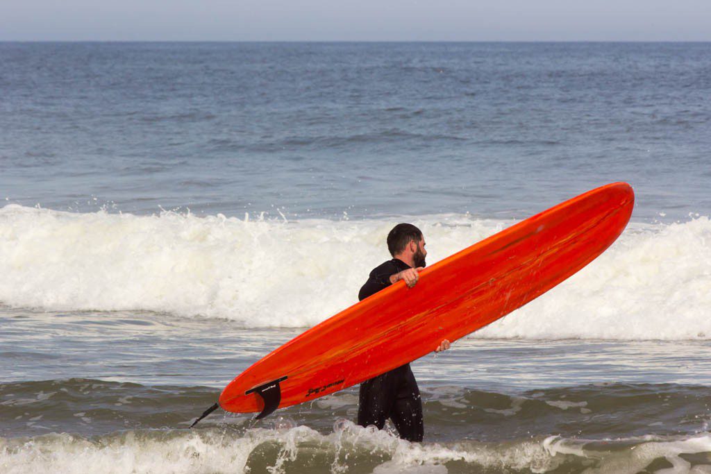 Surfer carrying his board around.