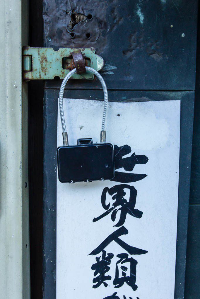 Tiny cable lock with a sign of some sort. I love the color green on the latch.