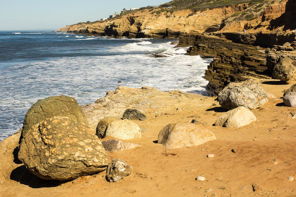 Lots of sand and large rocks on the coastline here