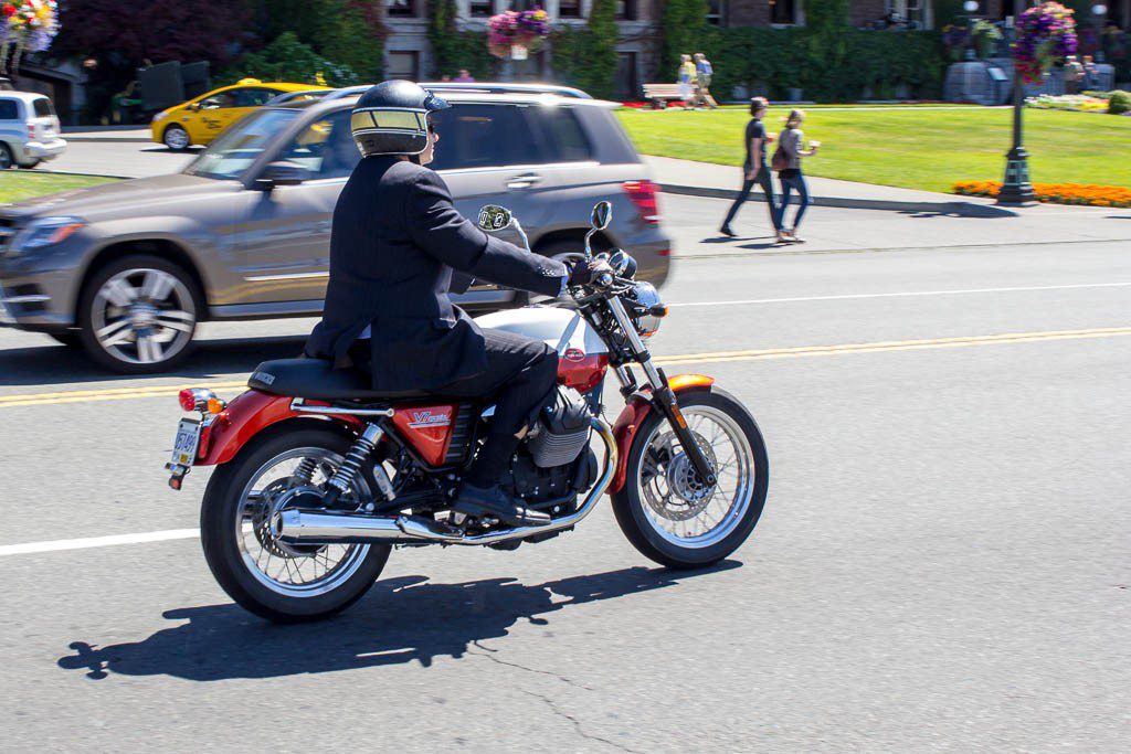 Guy in a suit on a Moto Guzzi.