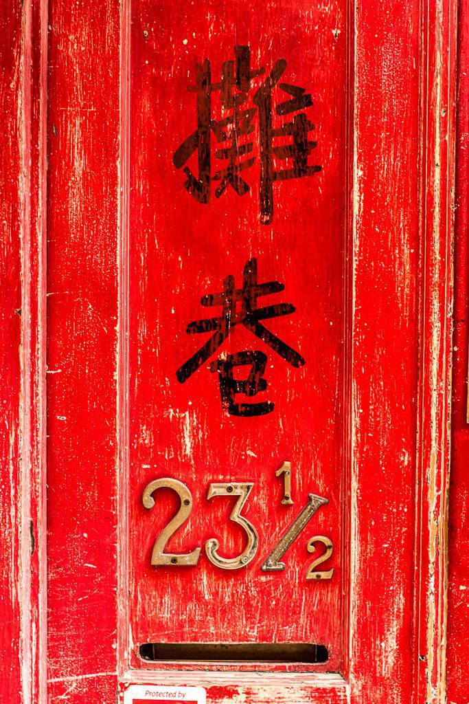 Faded red door. Number 23 1/2. Someone only gets half an apartment.