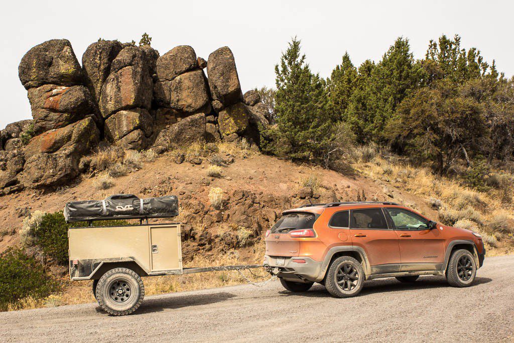 A dirty Jeep and trailer.