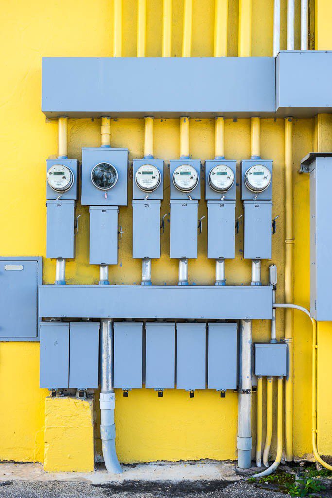 Power meters against a bright yellow building!