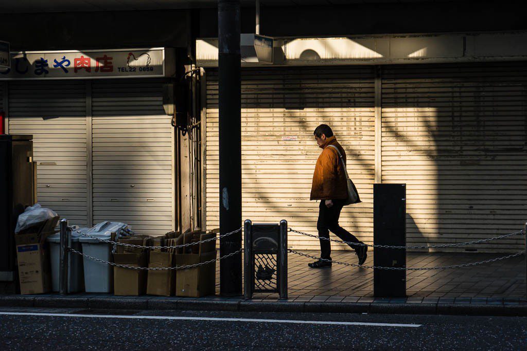 Man walking by closed shops